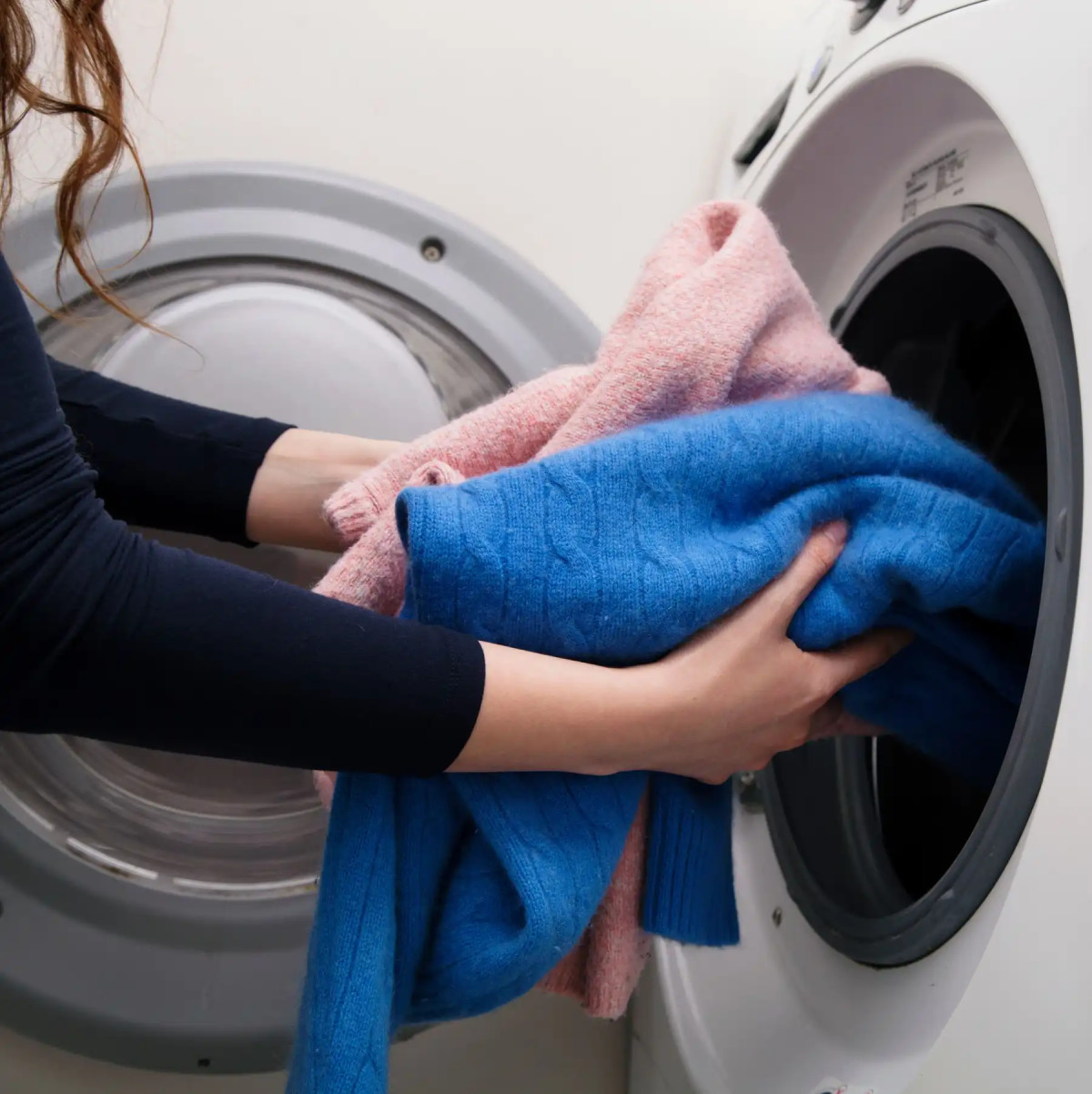Osoba odkładająca pranie w pralkę